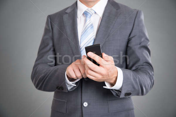 Businessman holding mobile phone Stock photo © AndreyPopov