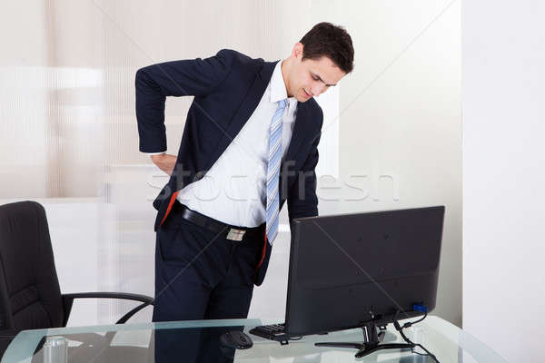 Biznesmen cierpienie ból w krzyżu biuro młodych działalności Zdjęcia stock © AndreyPopov
