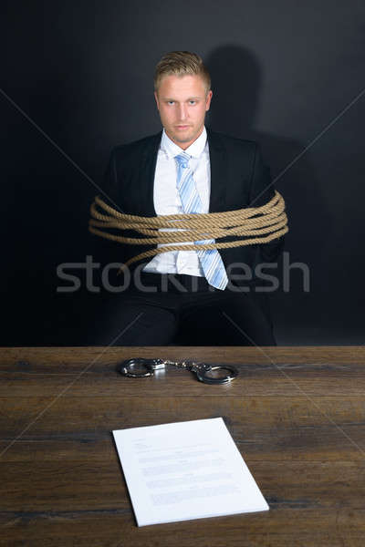 Businessman Tied With Rope Sitting In Front Of Table Stock photo © AndreyPopov