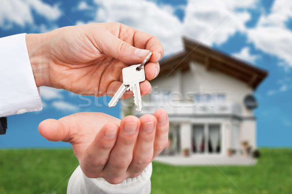 Real Estate Agent Giving Keys To Owner Against New House Stock photo © AndreyPopov