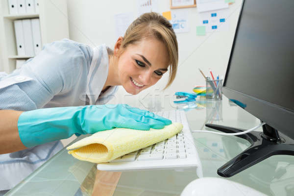 Maid Cleaning Keyboard At Desk Stock photo © AndreyPopov