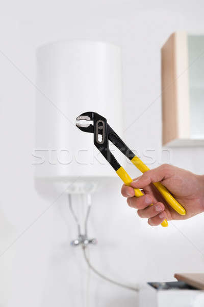 Person Hands With Wrench In Front Of Electric Boiler Stock photo © AndreyPopov