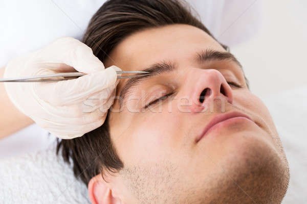 Beautician Hands Plucking Man Eyebrows With Tweezers Stock photo © AndreyPopov