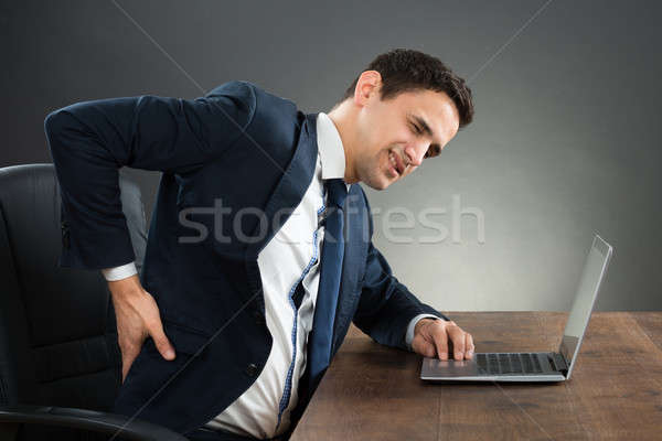 Businessman Suffering From Back Pain While Working On Laptop Stock photo © AndreyPopov