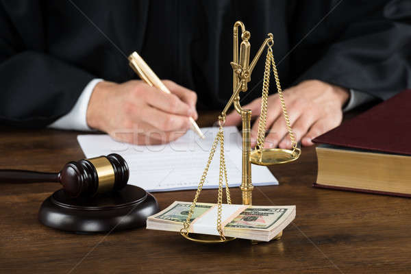 Judge Writing On Document With Banknotes In Weight Scale Stock photo © AndreyPopov