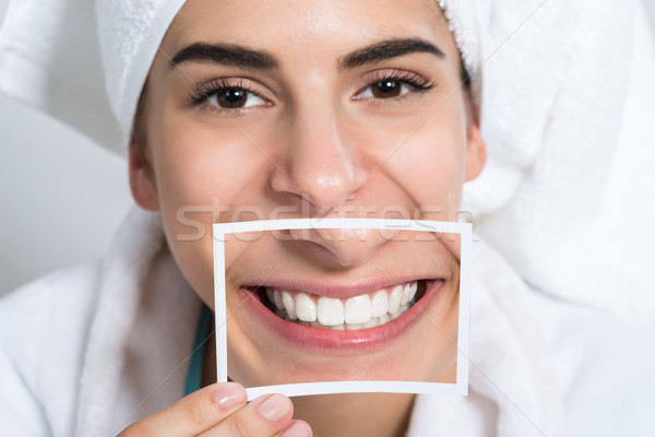 Woman Holding Photo Of Toothy Smile Stock photo © AndreyPopov