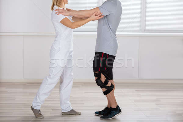 Physiotherapist Giving Support To A Male Patient Stock photo © AndreyPopov