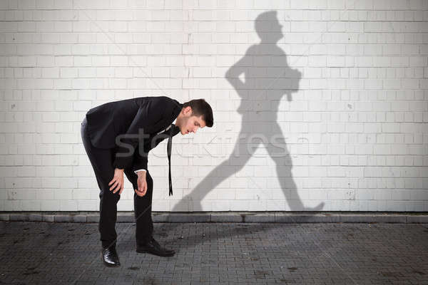 Businessman With Shadow Of Man Formed On Wall Stock photo © AndreyPopov