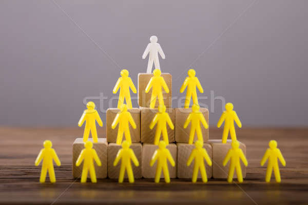 White Figure Standing On Top Of Yellow Human Figures Stock photo © AndreyPopov