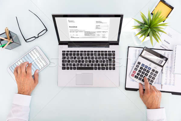 Businessman Analyzing Invoice On Laptop Stock photo © AndreyPopov