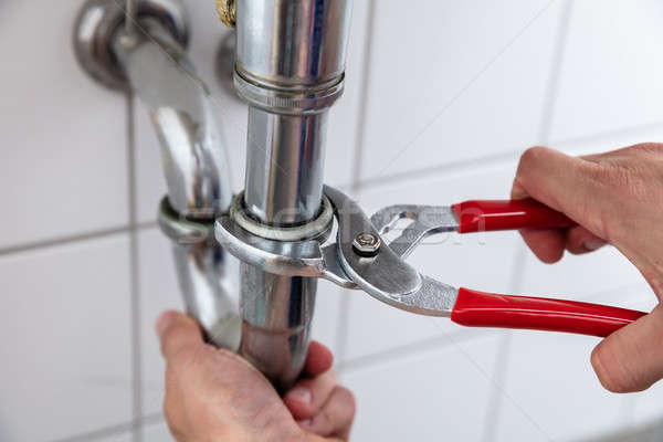Plumber Repairing Sink With Adjustable Wrench Stock photo © AndreyPopov