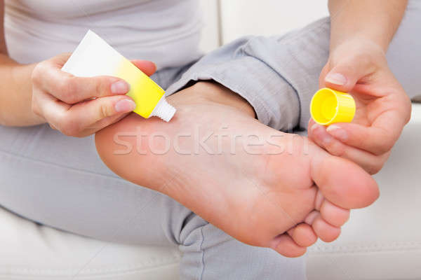 Woman applying cream on feet Stock photo © AndreyPopov
