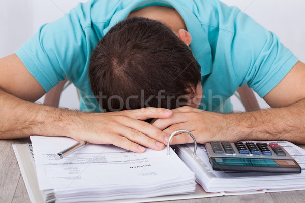Tired Man With Bills And Calculator At Desk Stock photo © AndreyPopov