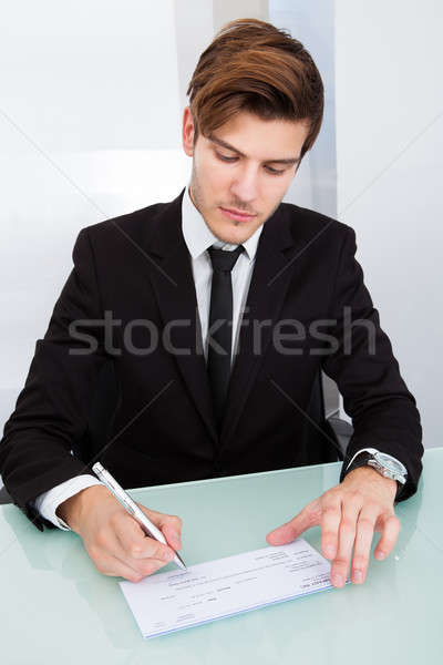 Empresário assinatura jovem enchimento mesa de escritório Foto stock © AndreyPopov