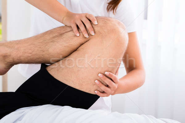 Therapist Hand Massaging Man's Leg In Spa Stock photo © AndreyPopov