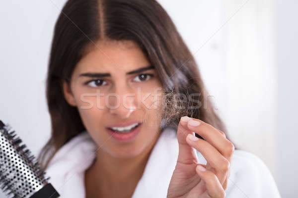 Foto stock: Mulher · roupão · de · banho · pente · olhando · cabelo