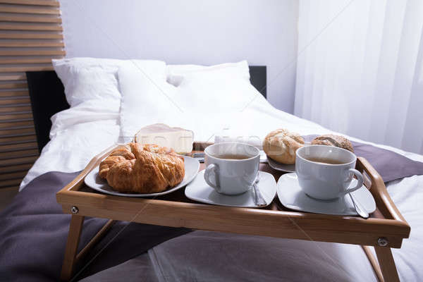 Croissants taza té cama frescos desayuno Foto stock © AndreyPopov