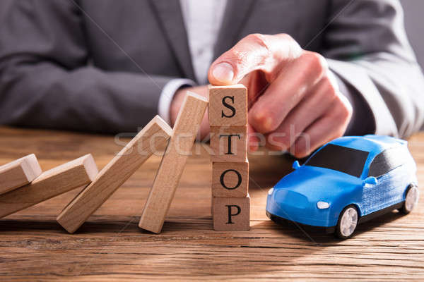 Falling Dominos Stopped By Human Finger On Wooden Blocks Stock photo © AndreyPopov