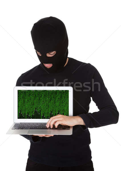 Stock photo: Hacker stealing data from a laptop
