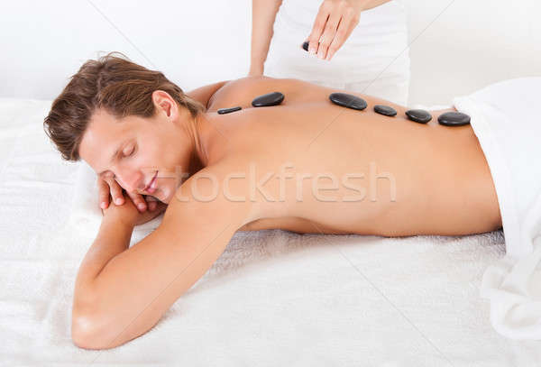 Man Getting Hot Stone Massage Stock photo © AndreyPopov