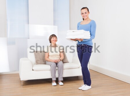Caretaker Carrying Towels With Senior Woman Sitting On Sofa Stock photo © AndreyPopov