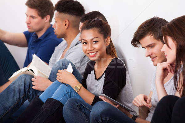 Stock photo: Smiling College Student Sitting With Classmates