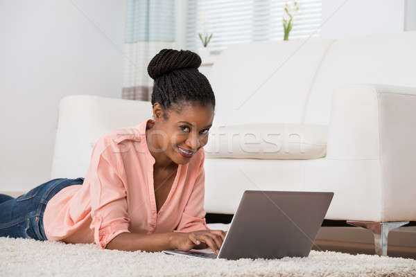 Femme utilisant un ordinateur portable tapis portrait souriant jeunes [[stock_photo]] © AndreyPopov