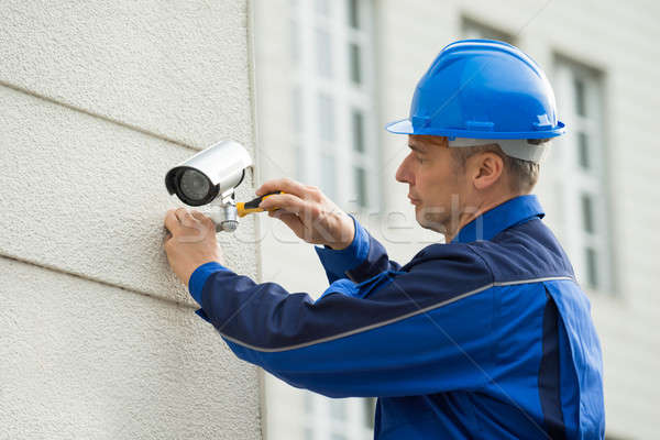 Mature Technician Installing Camera On Wall With Screwdriver Stock photo © AndreyPopov