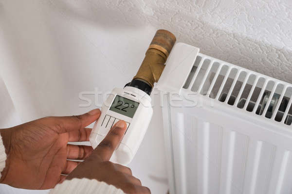 Woman's Hand Adjusting Temperature On Thermostat Stock photo © AndreyPopov