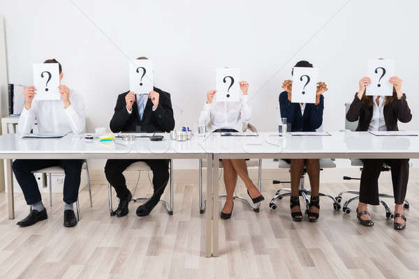 Geschäftsleute halten Fragezeichen Zeichen Gesicht Papier Stock foto © AndreyPopov