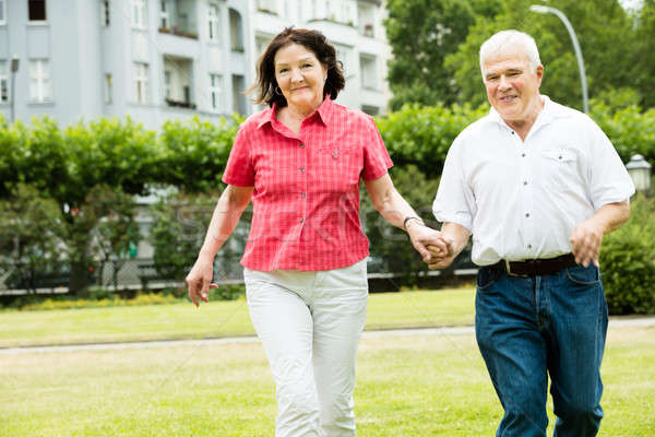 Stock photo: Couple Running In Park Holding Hands