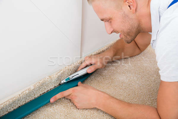 Man Cutting Carpet With Cutter Stock photo © AndreyPopov