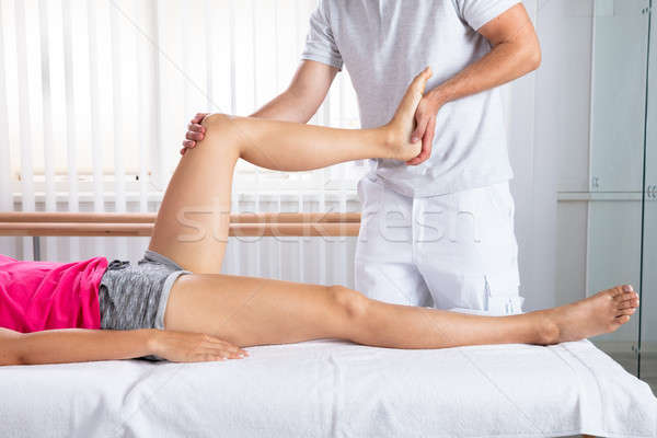 Male Therapist Stretching Woman's Leg Stock photo © AndreyPopov
