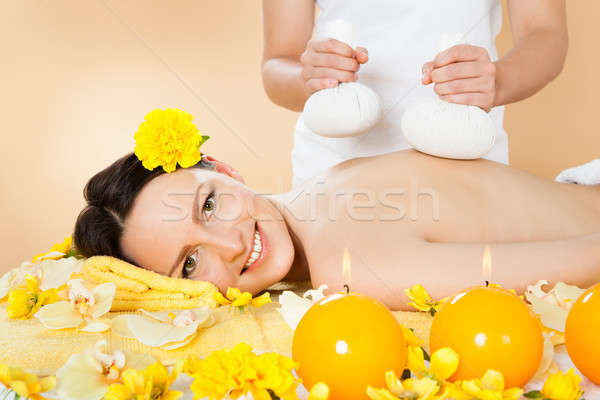 Woman Receiving Massage With Herbal Compress Stamps At Spa Stock photo © AndreyPopov