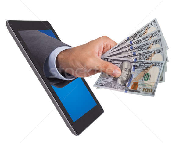 Hand Holding Dollar Bills Coming From Digital Tablet Stock photo © AndreyPopov