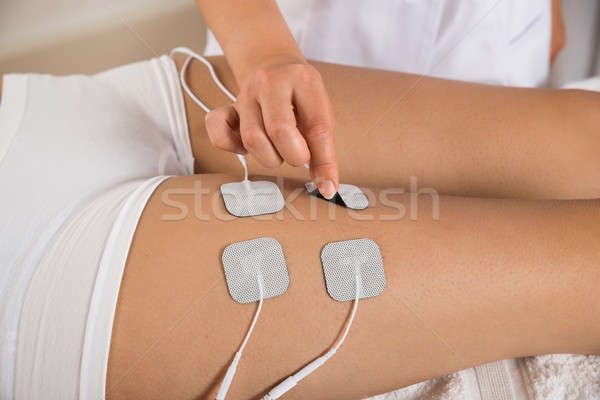 Therapist Placing Electrodes On Woman's Thigh Stock photo © AndreyPopov