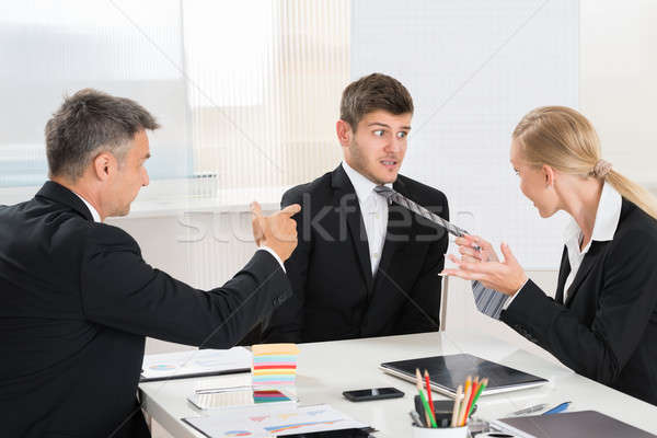 Stock photo: Two Businesspeople Quarreling To Young Businessman