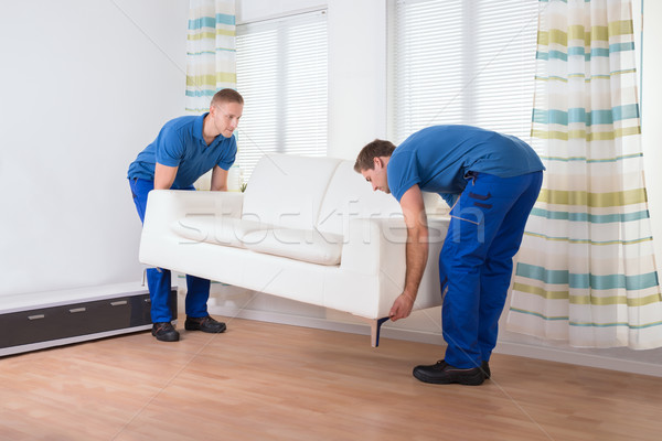 Movers Placing Sofa On Floor At Home Stock photo © AndreyPopov