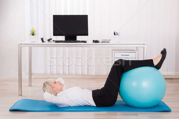 Businesswoman Exercising With Fitness Ball Stock photo © AndreyPopov