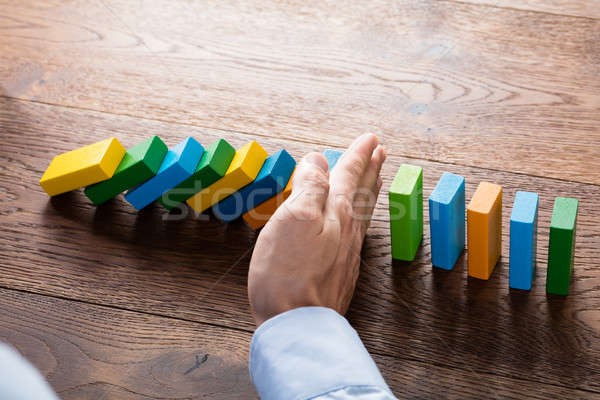 Person Hand Stopping Dominoes Stock photo © AndreyPopov