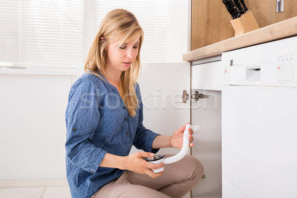 Woman Holding Sink Pipe In Kitchen Stock photo © AndreyPopov