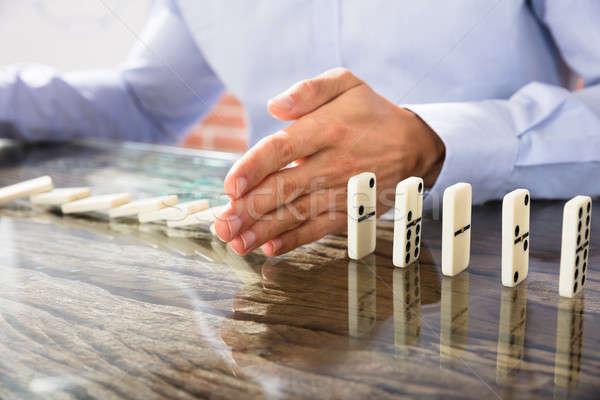 Businessman Stop Dominoes On Desk Stock photo © AndreyPopov