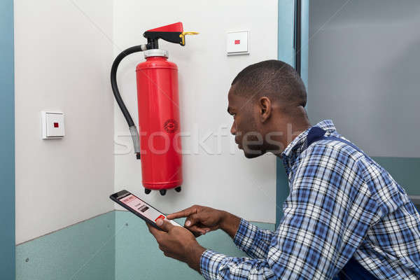 Male Professional Checking A Fire Extinguisher Stock photo © AndreyPopov