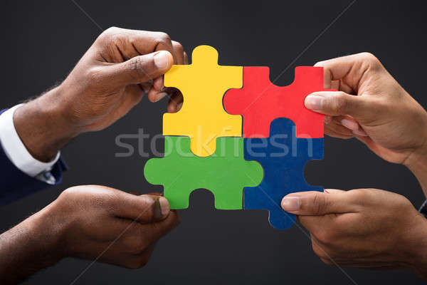 Hands Combining White Puzzle Pieces Stock photo © AndreyPopov