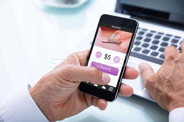 Businessman Donating Money Online On Mobile Phone Stock photo © AndreyPopov