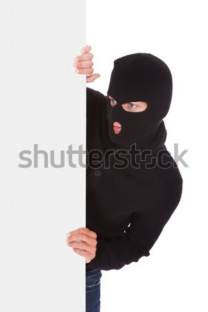 Stock photo: Thief looking around a blank sign