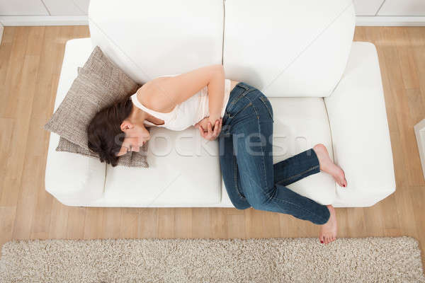 Kobieta cierpienie sofa widoku młoda kobieta Zdjęcia stock © AndreyPopov