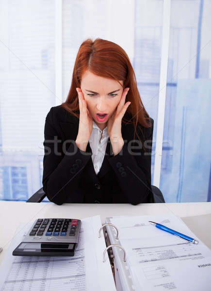 Shocked Businesswoman Looking At Tax Papers Stock photo © AndreyPopov