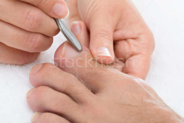 Manicurist Removing Cuticle From The Nail Stock photo © AndreyPopov