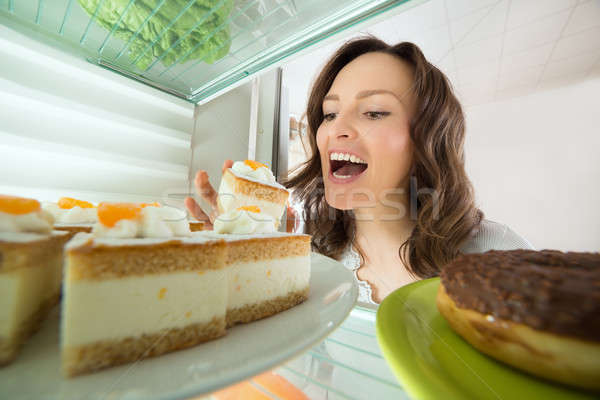 Woman Eating Slice Of Cake From Fridge Stock photo © AndreyPopov